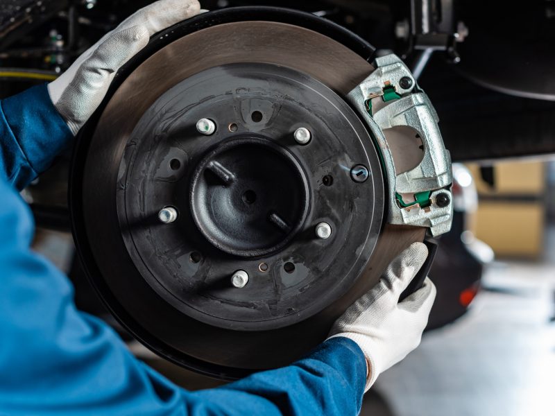 cropped view of mechanic adjusting assembled disc brakes with brake caliper